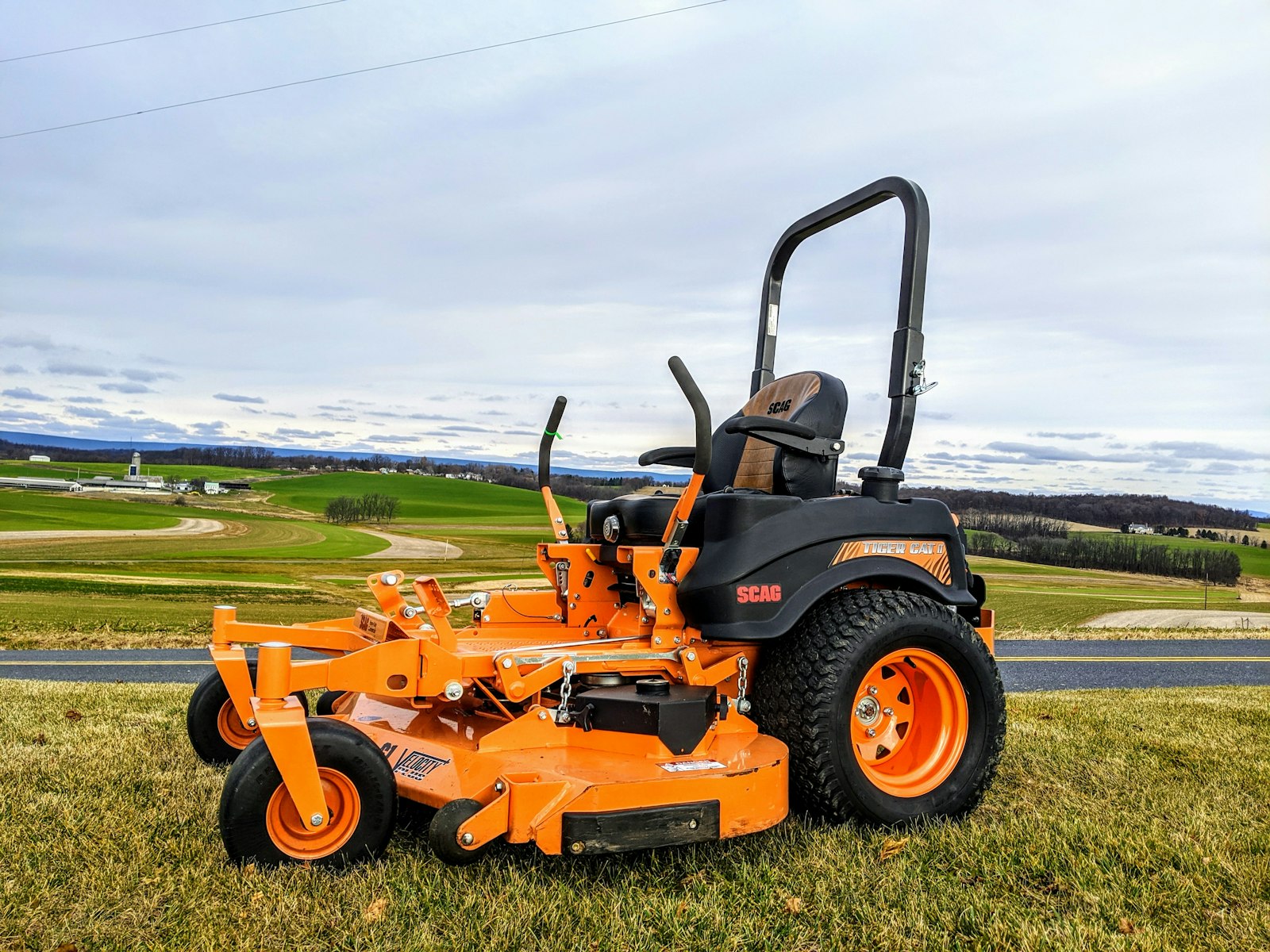 Zero-turn mower cutting a Hill Country slope in even passes.